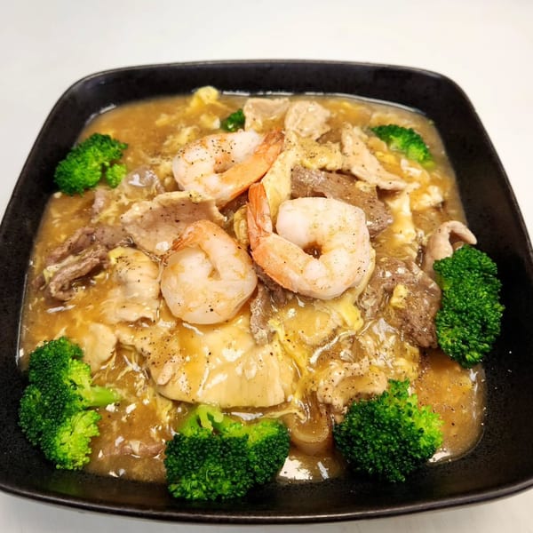 Noodle 501's gravy noodles with shrimp, beef, chicken, and broccoli in a black bowl.